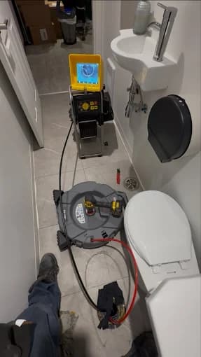 Dégorgeoir électrique en place lors d'une intervention sur une toilette